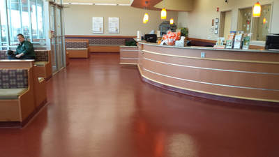 a waiting area of a building with a solid red color of epoxy flooring